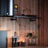 Rustic interior design in kitchen with floating shelf made from wooden board and dark iron supports