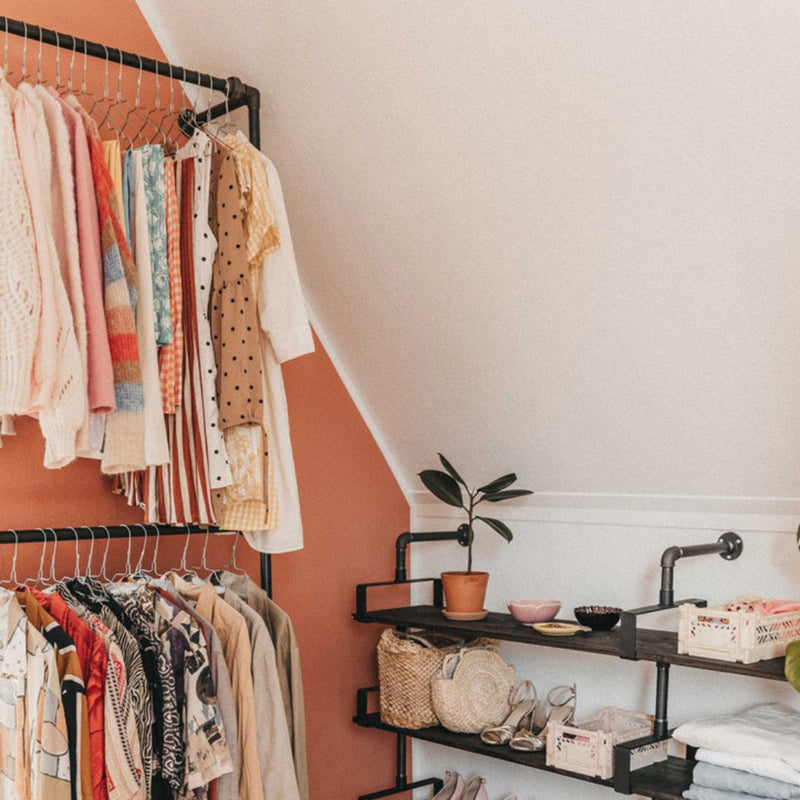 Open closet design with wall mounted rack and shelves made from dark iron pipes for stability