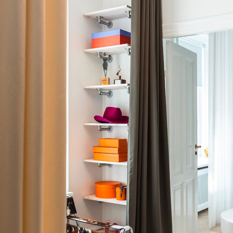 Simple shelving system with small wall mounted shelves made from wood and water pipes